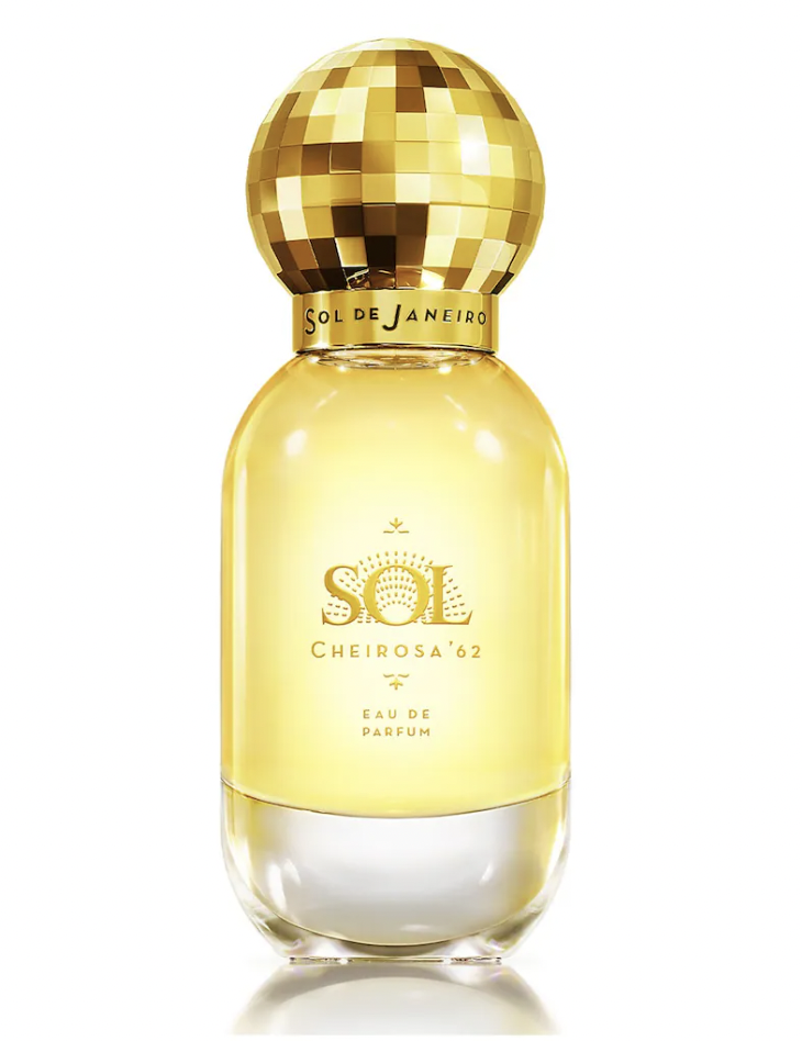 A bottle of Sol de Janeiro's Sol Cheirosa '62 Eau de Parfum, featuring a golden yellow liquid in a clear, elegant bottle with a disco ball-inspired cap. The label includes the brand and product name.